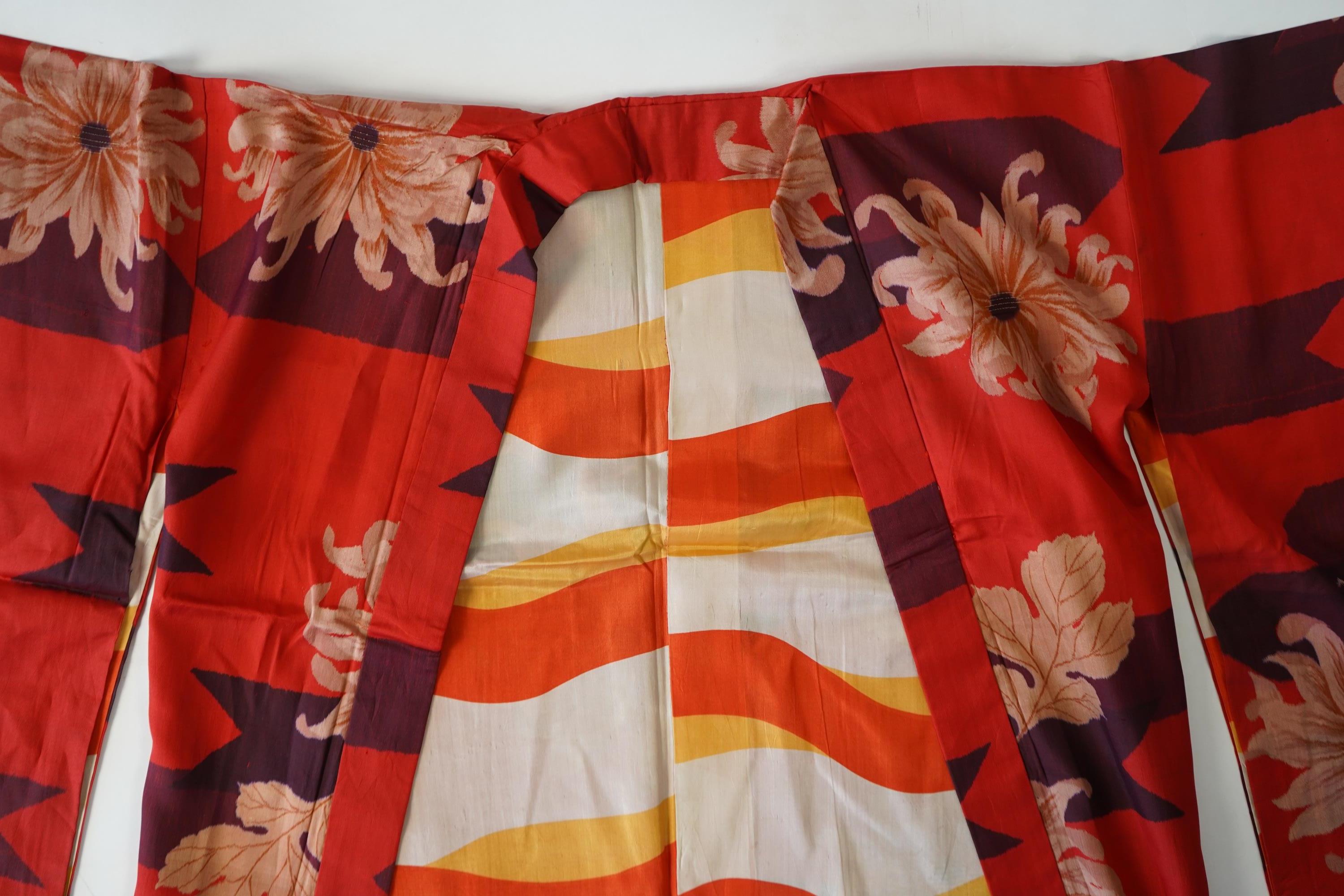 Three Japanese mid 20th century ‘Haori’ printed silk jackets. One red with brightly coloured lining and rust brown floral silk lining. All with large kimono sleeves. Grey patterned Haori, 79cm long., Condition - good